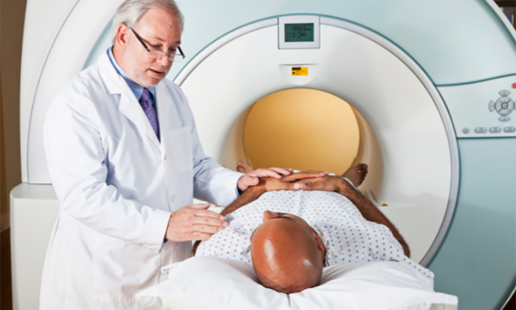 a stock image of a male patient in an MRI machine with the doctor standing by