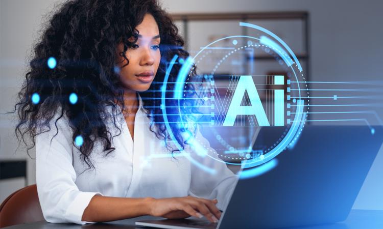 Stock image of a woman using a laptop with a graphical "AI" overlay