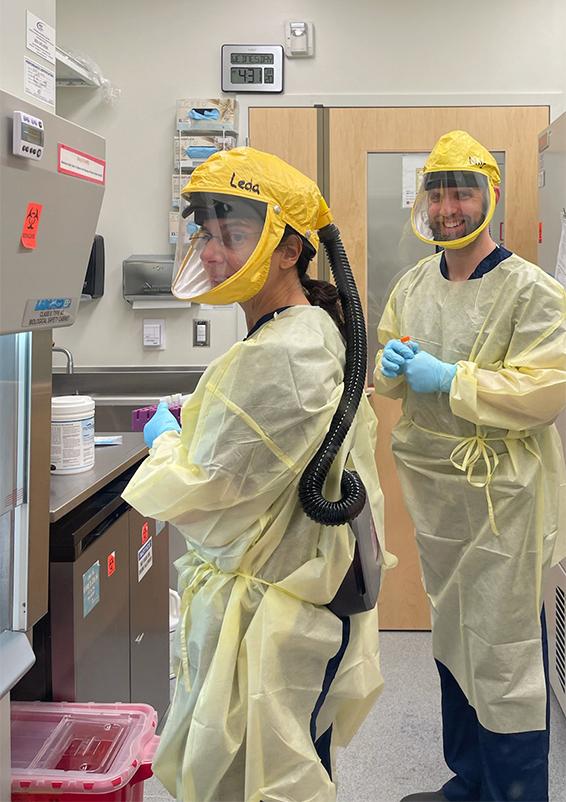 Leda Bassit and Nils Schoof in gowns and respirators in a Biosafety Level 3 lab at Emory.