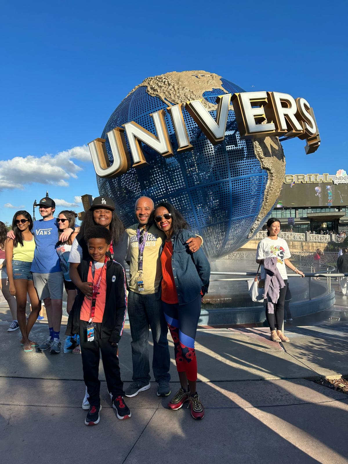 The Beyah family at Universal Studios, standing in front of a globe and Universal sign