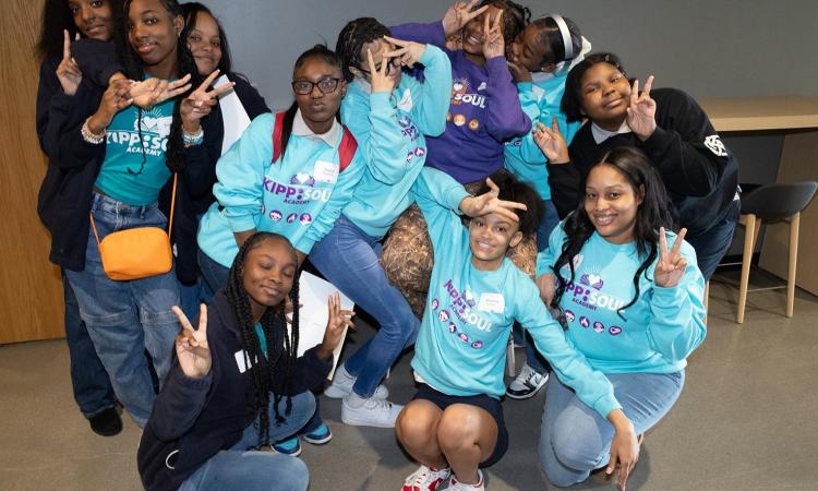 A group of students from KIPP SOUL Academy poses holding peace signs at the Students Exploring Engineering event in 2024.