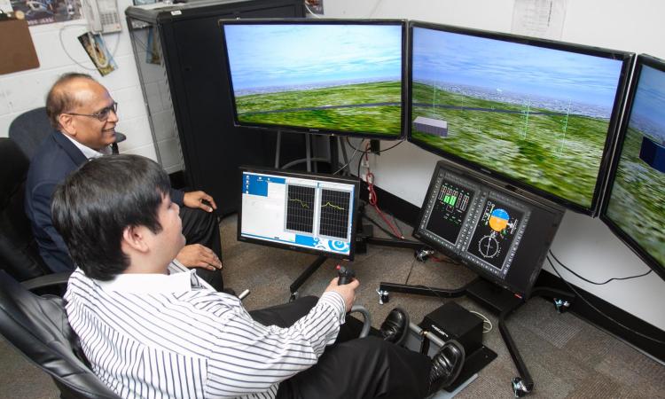 student and faculty member working with simulator
