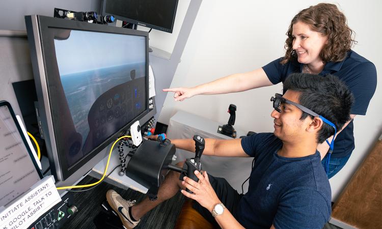 AE Professor Karen Feigh works with a student in a flight simulator