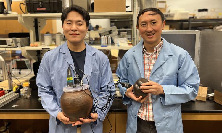 David Hu, professor of mechanical engineering, and Soohwan Kim, a second-year Ph.D. student, in their lab with the onggi they used in fermentation experiments.
